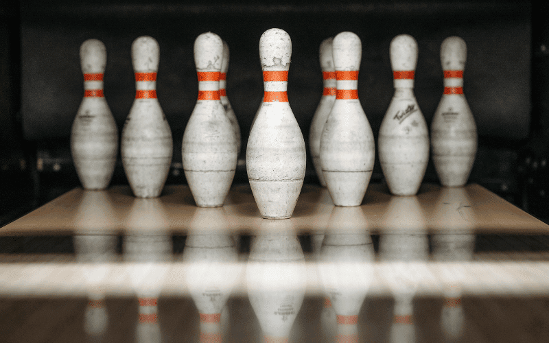 Bowling pins arranged on lane, ball rolling towards them